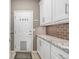 Mud room with white cabinets, granite countertops, and convenient door with pet access at 9552 E Caley Cir, Englewood, CO 80111