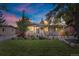 Charming single-story home with a lush, well-manicured front yard and mature trees at dusk at 250 W Midway Blvd, Broomfield, CO 80020