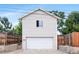 Detached two-story garage with white siding, white door and a partial view of the fenced yard at 250 W Midway Blvd, Broomfield, CO 80020