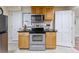 Kitchen featuring stainless steel appliances, light wood cabinets, a built-in microwave, and tiled floors at 250 W Midway Blvd, Broomfield, CO 80020