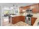 Eat-in kitchen features stone countertops, stainless steel appliances and warm wood cabinetry at 250 W Midway Blvd, Broomfield, CO 80020