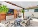 Covered patio features an outdoor television, seating area, and a lush garden view for comfortable outdoor living at 250 W Midway Blvd, Broomfield, CO 80020