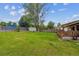 Lush backyard with storage shed, wooden deck, and a mix of open lawn and mature trees at 6508 S Garland Way, Littleton, CO 80123