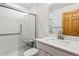 Modern bathroom featuring a walk-in shower with glass door, grab bars, and updated fixtures at 6508 S Garland Way, Littleton, CO 80123
