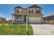 Two-story home with a covered porch, an attached two-car garage, and a well-maintained lawn at 1005 Ryland Rd, Brighton, CO 80603