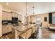 Open kitchen with a central island, gray cabinets, stainless steel appliances, and hardwood floors at 1005 Ryland Rd, Brighton, CO 80603