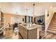 Open kitchen layout with an island, seamless flow to the dining area, and a view of the staircase at 1005 Ryland Rd, Brighton, CO 80603