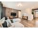 Modern living room featuring a plush sofa, stylish wall decor, and a staircase leading to the upper level at 1005 Ryland Rd, Brighton, CO 80603