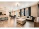 Open-concept living space with hardwood floors, a large sofa, and a seamless flow to the dining area at 1005 Ryland Rd, Brighton, CO 80603
