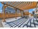 Outdoor patio area with wooden pergola, dining set, grill, and privacy fence, perfect for entertaining at 1005 Ryland Rd, Brighton, CO 80603