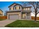 Charming two-story home with gray siding, brick accents, a well-manicured lawn, and attached two-car garage at 11980 Swansea Dr, Parker, CO 80134