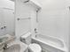 Bathroom with a white tiled shower and bath, granite countertop, and white cabinets at 6852 S Dover Way, Littleton, CO 80128