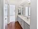 Bathroom featuring light wood floors, white cabinets, white and gray countertop, and a doorway to the bedroom at 6852 S Dover Way, Littleton, CO 80128