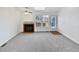 Bright living room featuring a fireplace, plush carpet, and natural light from the backyard at 6852 S Dover Way, Littleton, CO 80128