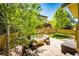 Outdoor patio featuring comfortable seating around a rustic wood table and shade from mature trees at 4970 Laurelglen Ln, Highlands Ranch, CO 80130