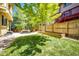 Spacious backyard featuring a well-maintained lawn, a wooden fence, and a cozy seating area under a mature tree at 4970 Laurelglen Ln, Highlands Ranch, CO 80130