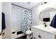 Bathroom featuring white subway tile, a shower/tub combo with stylish curtain, and modern round mirror and sink at 4970 Laurelglen Ln, Highlands Ranch, CO 80130