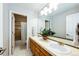 Bright bathroom with double sink vanity, large mirror, white tile flooring and open access to the tub and shower area at 4970 Laurelglen Ln, Highlands Ranch, CO 80130