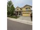 Charming yellow two-story home featuring a spacious driveway and well-manicured lawn at 4970 Laurelglen Ln, Highlands Ranch, CO 80130