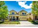 Charming yellow two-story home with covered front porch and well-manicured lawn at 4970 Laurelglen Ln, Highlands Ranch, CO 80130