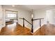 Well-lit hallway with a view into a bedroom, showcasing hardwood floors and classic architectural details at 4970 Laurelglen Ln, Highlands Ranch, CO 80130