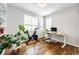 Bright home office with a standing desk, indoor plants, and a Peloton bike by the window at 4970 Laurelglen Ln, Highlands Ranch, CO 80130
