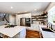 Bright kitchen featuring white cabinets, stainless steel appliances, and floating wood shelves for added storage space at 4970 Laurelglen Ln, Highlands Ranch, CO 80130