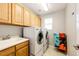 Laundry room features a modern washer and dryer, sink, storage cabinets, and a bright window for natural light at 4970 Laurelglen Ln, Highlands Ranch, CO 80130