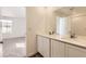 Bright bathroom features double vanity sinks with modern faucets, complemented by a well-lit mirror and nearby shower at 22015 E 39Th Ave, Aurora, CO 80019