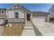 Charming home featuring stone accents, vertical siding, well-maintained landscaping and an attached two-car garage at 22015 E 39Th Ave, Aurora, CO 80019