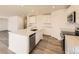 Modern kitchen with stainless steel appliances, white cabinets, quartz countertops, and a large center island at 22015 E 39Th Ave, Aurora, CO 80019