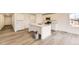 Open-concept kitchen boasts white cabinetry, stainless steel appliances, a center island, and sleek hardwood floors at 22015 E 39Th Ave, Aurora, CO 80019