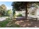 Serene backyard featuring mature trees, garden beds, and an inviting patio area at 950 Everett St, Lakewood, CO 80215
