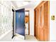 Inviting entryway featuring a stylish front door, tile flooring and a closet with wood paneled doors at 950 Everett St, Lakewood, CO 80215