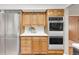 Traditional kitchen featuring stainless steel refrigerator and double oven, wood cabinets, and white countertop at 950 Everett St, Lakewood, CO 80215