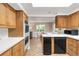 Bright kitchen with wooden cabinets, white countertop, black dishwasher, and attached dining area at 950 Everett St, Lakewood, CO 80215