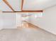 Bright living room featuring neutral carpet, white walls, and exposed wood beams at 950 Everett St, Lakewood, CO 80215