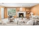 Cozy living room featuring a fireplace, wood paneling, and a large window with natural light at 950 Everett St, Lakewood, CO 80215