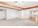 Open-concept living room featuring neutral carpet, white walls, and exposed wood beams at 950 Everett St, Lakewood, CO 80215