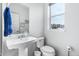 Clean, modern bathroom with a pedestal sink, toilet, and window for natural light at 10031 Town Ridge Ln, Lone Tree, CO 80124