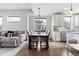 Open dining room features a modern chandelier, dark wood table, and adjacent living space at 10031 Town Ridge Ln, Lone Tree, CO 80124