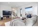 Inviting living area featuring hardwood floors, a large TV, and staircase at 10031 Town Ridge Ln, Lone Tree, CO 80124
