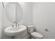 Bright and modern powder room featuring a pedestal sink, sleek fixtures, and a contemporary design at 8250 Snake River St, Littleton, CO 80125