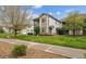 Attractive condo building with stone accents, a well-manicured lawn, and mature shade trees at 3262 E 103Rd Dr # 1806, Thornton, CO 80229