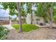 A backyard features a patio, lawn, landscaping, and mature trees at 4858 S Queen St, Littleton, CO 80127