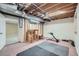 The unfinished basement area includes fitness equipment and access to another room at 4858 S Queen St, Littleton, CO 80127