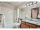 Bright bathroom with shower-tub and granite vanity, providing functionality and style at 4858 S Queen St, Littleton, CO 80127