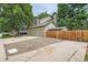 A view of the house exterior with a long driveway, two-car garage, and wooden fence at 4858 S Queen St, Littleton, CO 80127