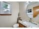 The powder room has granite counters, modern fixtures, and a window for natural light at 4858 S Queen St, Littleton, CO 80127