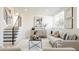 Bright living room with modern decor and a staircase featuring black metal railings at 1390 S Jasmine Way, Denver, CO 80224